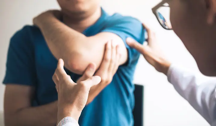 Mann mit Gliederschmerzen beim Arzt