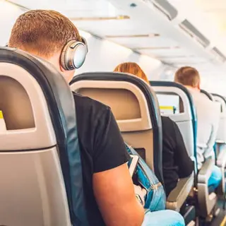 Mann mit Kopfhörern im Flieger