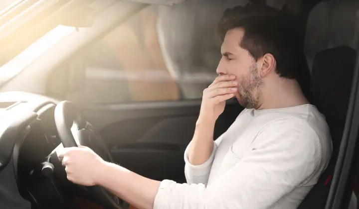 Autofahrer mit Schlafproblemen gähnt