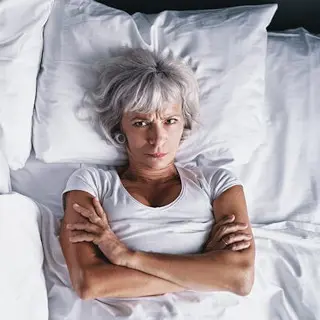 Frau liegt nachts wach