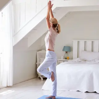 Frau beim Yoga im Schlafzimmer