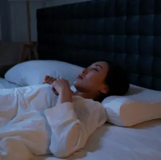 Frau liegt bewegungslos im Bett