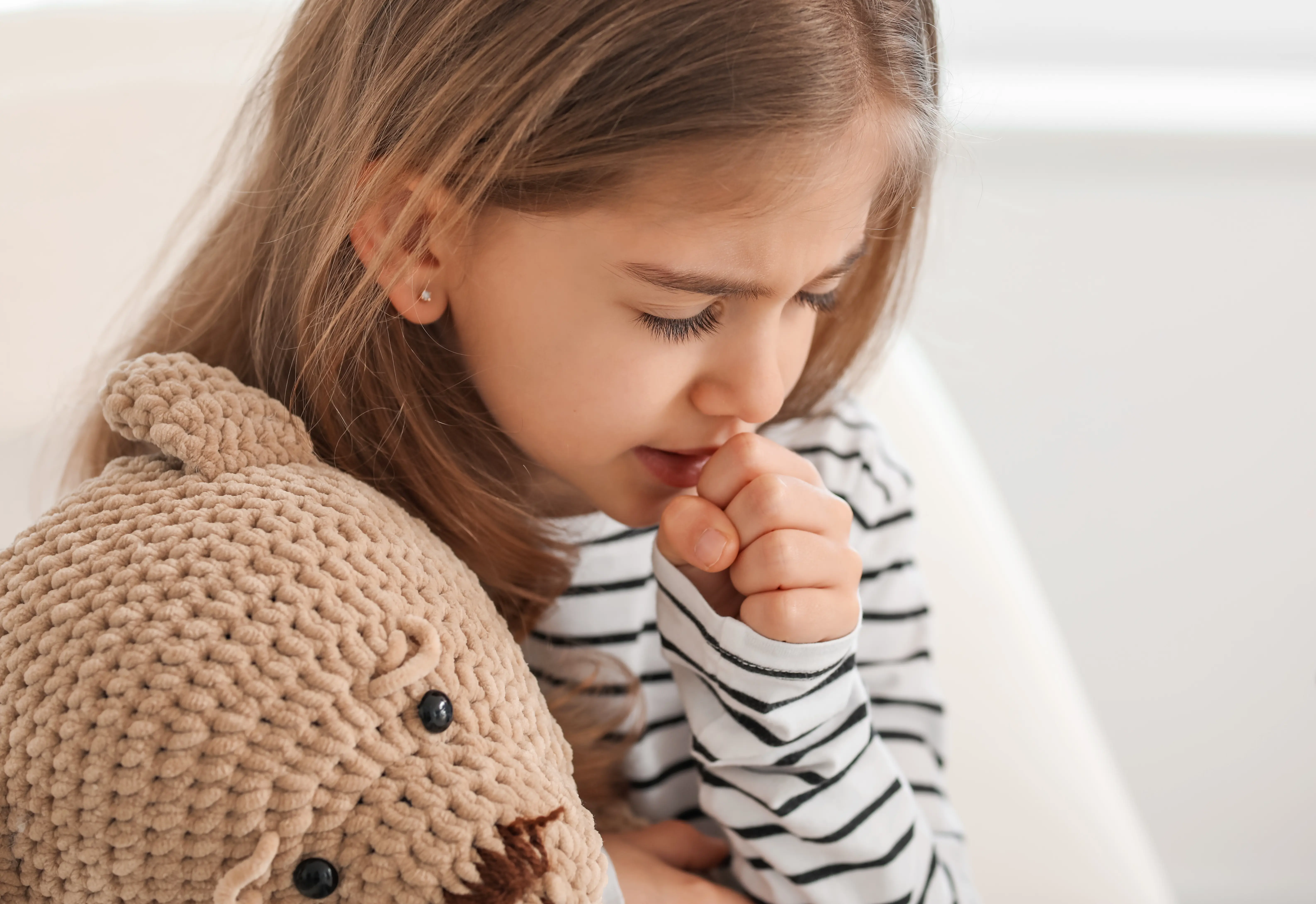Mädchen mit Teddy hustet