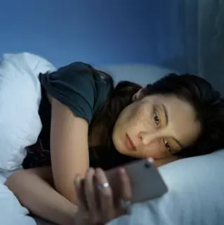 Frau im Bett am Handy